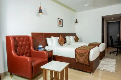 a hotel room with a bed and a chair at THE RUNWAY HOTEL in Cochin