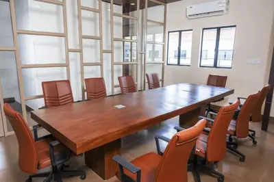 a conference room with a large wooden table and chairs at THE RUNWAY HOTEL in Cochin