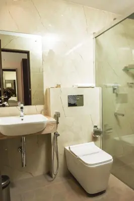 a bathroom with a toilet and a sink and a shower at THE RUNWAY HOTEL in Cochin