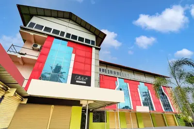 a building with colorful windows and a palm tree at Super Collection O Coorg in Madikeri