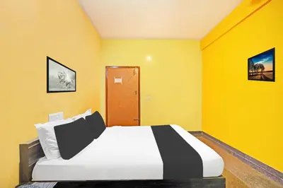 a bedroom with a bed with yellow walls at Super Collection O Coorg in Madikeri
