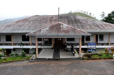 a house with a thatched roof with a porch at AC MIST in Munnar