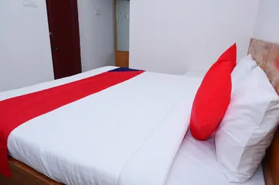 a bed with two red and white pillows on it at Hotel Stay Shine in Mysore