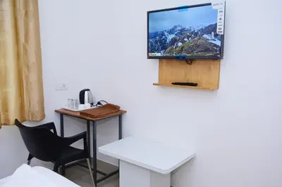 a room with a table and a tv on the wall at Hotel Stay Shine in Mysore