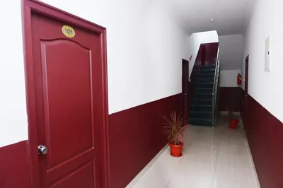 a red door leading to a hallway with a staircase at Hotel Stay Shine in Mysore