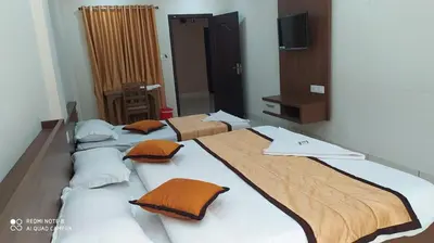 a group of three beds in a room at Kallada Residency in Perintalmanna