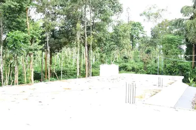 a white building with trees in the background at Pauls Retreat Wayanad , Family Resort in Wayanad