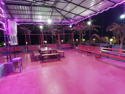 a room with benches and a table and lights at Pauls Retreat Wayanad , Family Resort in Wayanad