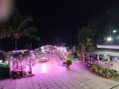 a night view of a patio with lights at Pauls Retreat Wayanad , Family Resort in Wayanad