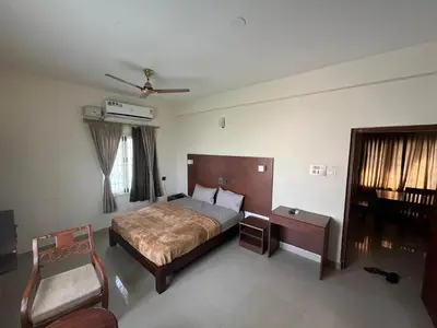 a bedroom with a bed and a chair at PPH Living Athithi Inn Corporate Stay in Coimbatore