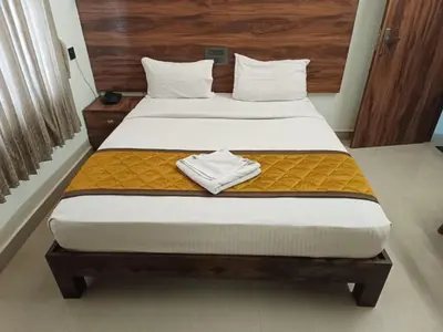 a bedroom with a large bed with a wooden headboard at PPH Living Athithi Inn Corporate Stay in Coimbatore