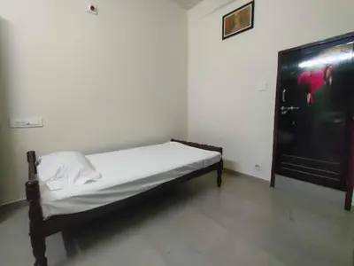 a small bedroom with a bed and a tv at Jinnens Tourist Home in Ponnāni