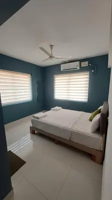 a bedroom with a bed with blue walls and a ceiling at GDC - Apartment suites in Ernakulam