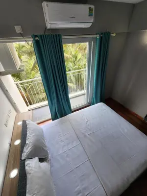 a small bedroom with a bed and a window at GDC - Apartment suites in Ernakulam
