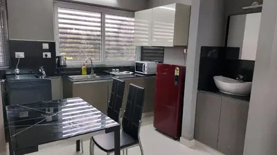 a kitchen with a red refrigerator and a table at GDC - Apartment suites in Ernakulam