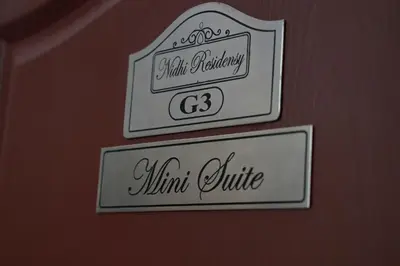 two signs on the wall of a room at NIDHI RESIDENCY in Guruvāyūr
