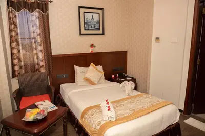 a hotel room with a bed and a table with a chair at THE PEBBLE Boutique Hotel in Tiruppūr