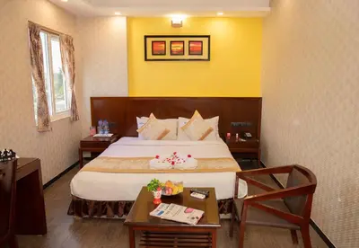 a hotel room with a bed and a table at THE PEBBLE Boutique Hotel in Tiruppūr