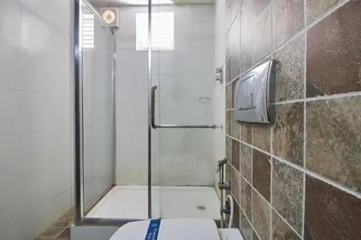 a shower stall with a toilet in a bathroom at THE PEBBLE Boutique Hotel in Tiruppūr