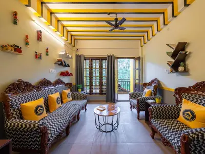 a waiting room with couches and a table at The Hosteller Coorg Rainforest, Madikeri in Madikeri