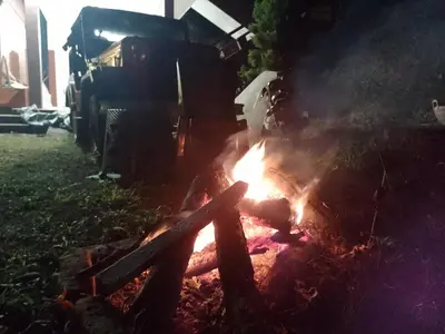 a fire in the grass with a truck in the background at Chilly Coorg in Virajpet