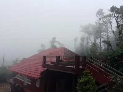 a house with a red roof in the fog at Chilly Coorg in Virajpet