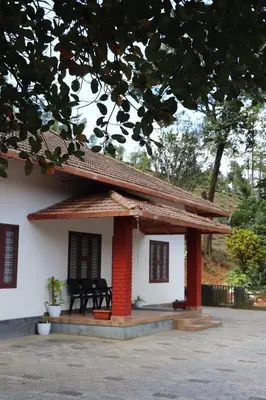 a small white house with a red roof at Perya Hills in Periya