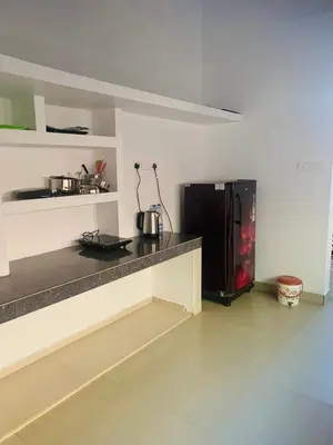 a kitchen with a counter with a microwave and a refrigerator at Perya Hills in Periya