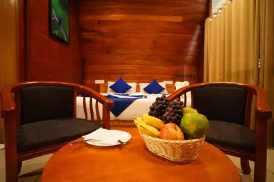 a basket of fruit sitting on a table with two chairs at Misty Morning Resorts Wayanad in Ambalavayal