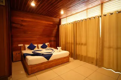 a bedroom with a bed with a wooden wall at Misty Morning Resorts Wayanad in Ambalavayal