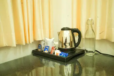 a coffee maker and a bottle of water on a table at Misty Range Resorts , Marayoor in Marayoor