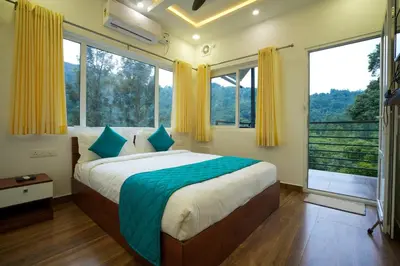 a bedroom with a large bed and large windows at Misty Range Resorts , Marayoor in Marayoor