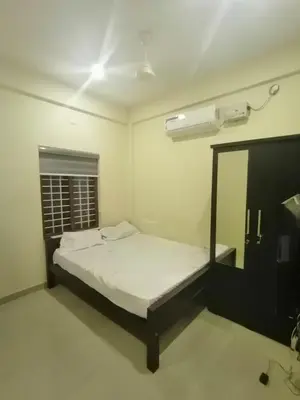 a bedroom with a bed and a mirror in it at Queens Residency in Trichūr