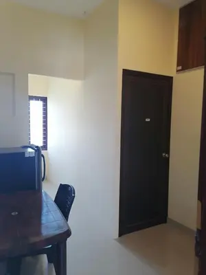 a room with a wooden table and a black door at Queens Residency in Trichūr
