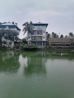 a large building next to a large body of water at Green Garden Apartments in Kodungallūr