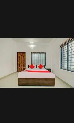 a bedroom with a large bed with red pillows at Subramania Arcade in Trichūr