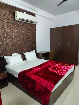 a bedroom with a bed with a red blanket at Subramania Arcade in Trichūr