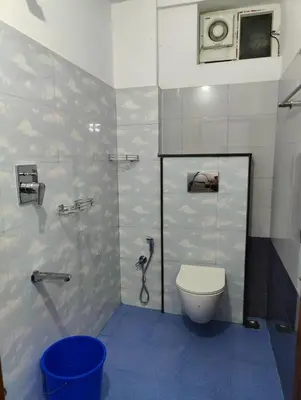 a small bathroom with a toilet and a shower at Subramania Arcade in Trichūr