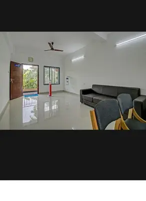 a living room with a black couch and chairs at Subramania Arcade in Trichūr