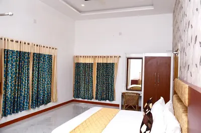 a bedroom with a bed and blue curtains at NIRVANA HOLISTIC LIVING in Varagampadi