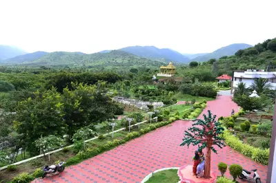 a view of a resort with mountains in the background at NIRVANA HOLISTIC LIVING in Varagampadi