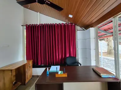an office with a desk and a red curtain at Forest and River Edge Resort in Kannur