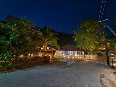 a house lit up at night with lights at Forest and River Edge Resort in Kannur