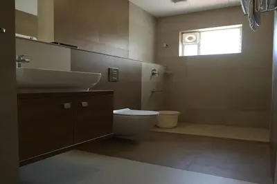 a bathroom with a sink and a toilet and a window at Ashirvad Lawns Hotel & Convention Centre in Kozhikode