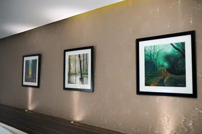 a row of framed paintings on a wall at Emarald Hotel Calicut in Kozhikode