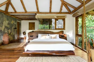 a bedroom with a large bed and windows at Earthitects Holiday Experiences,Wayanad in Kalpetta