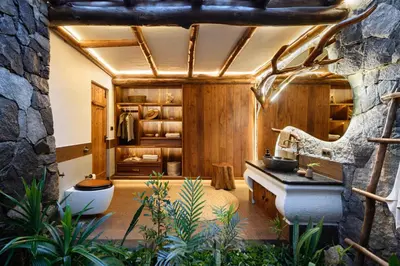 a bathroom with a sink and a stone wall at Earthitects Holiday Experiences,Wayanad in Kalpetta
