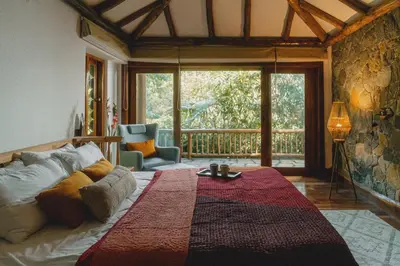 a bedroom with a bed and a large window at Earthitects Holiday Experiences,Wayanad in Kalpetta
