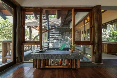 a room with a stone bench in front of windows at Earthitects Holiday Experiences,Wayanad in Kalpetta