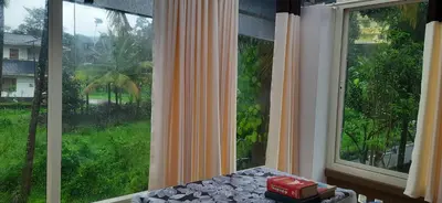 a room with a large window with a view at NEST Mdy in Mananthavady